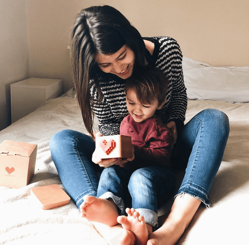 A mother and toddler reading a Lovebox message together at home.